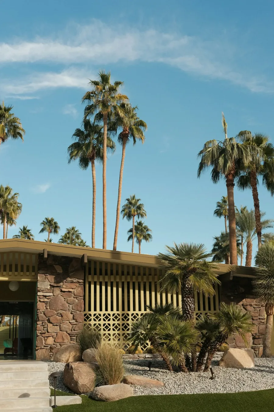 Mid-century California architecture framed by palms and a clear blue sky